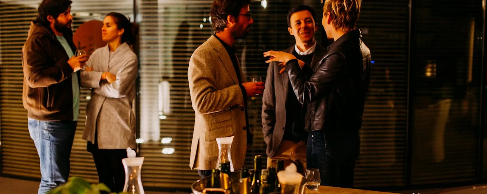 Guests talking in small groups around a candlelit table (illustrative)