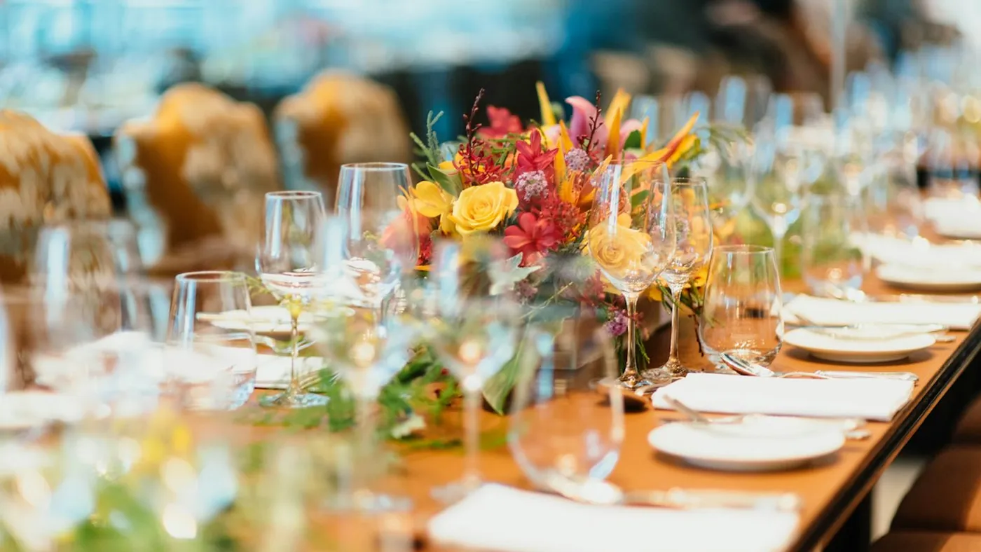 A long table set with flowers and glassware for a members dinner (illustrative)